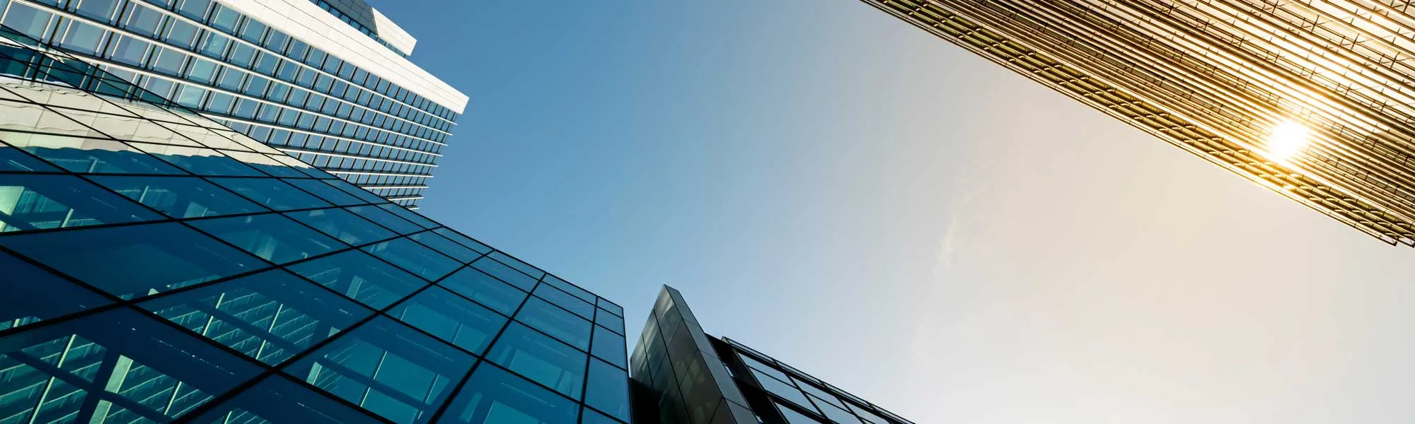 A tall building with modern architecture, standing against a clear blue sky